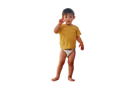 Baby is standing on the window sill, gazing out at the sky and risking a life-changing accident, isolated on white background. Kid aged two yearsの写真素材