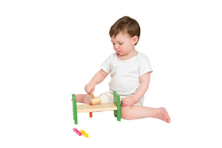 Happy baby play educational toys on studio, isolated on white background. Portrait of a smiling child playing while sitting on the floor, isolated on white background. Kid about two years oldの写真素材