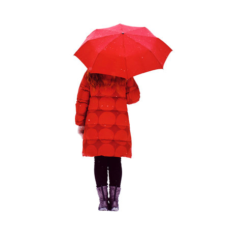 A happy woman stands with a red umbrella in her hands, a winter park with snow-covered trees, isolated on a white backgroundの写真素材