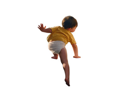 The little baby is dangerously climbing up the window sill, oblivious to the hazard, isolated on white background. Kid aged two yearsの写真素材