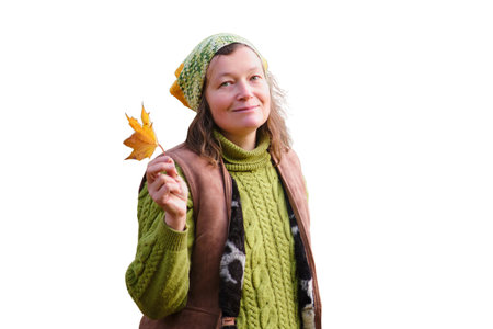 Portrait of woman in autumn park with yellow maple leaf, isolated on white background. Portrait of a 52-year-old womanの写真素材
