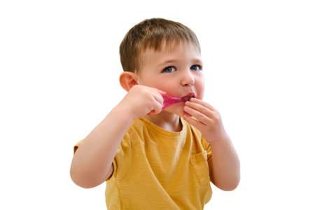 With a toothbrush in hand, the baby sits contentedly in her crib, cleaning her pearly whites, isolated on white background. Kid aged about two years (one year eleven months)の写真素材
