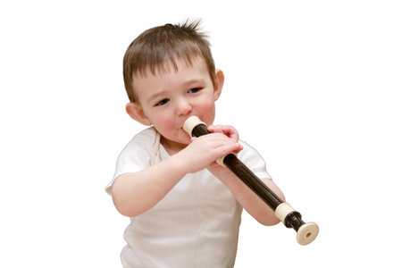 Toddler baby plays the flute sitting on the floor in the children's room, isolated on white background. Child boy playing musical instruments. Kid aged one year eight monthsの写真素材