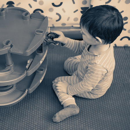 Toddler baby is playing with toys in kindergarten. Happy child boy in the playroom. Kid aged one year nine monthsの写真素材