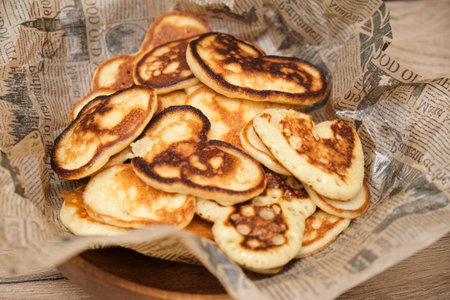 Pancakes with honey in a wooden bowl on a wooden background, love heart shape