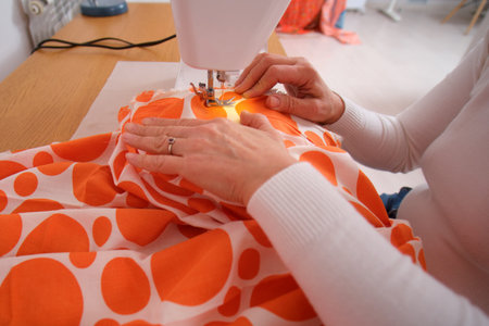 Close-up of a woman's hands sewing on a sewing machine