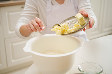 Adding butter to the dough to make a pie. Process of cooking pecan pie in home kitchen for American Thanksgiving Day.の写真素材