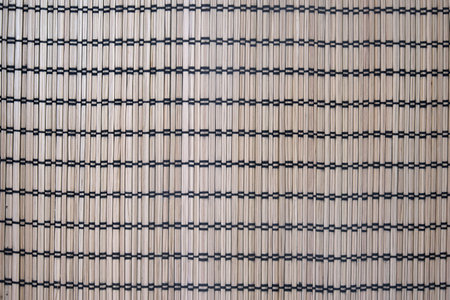 Natural bamboo mat with black thread grid pattern. Seamless woven texture background. Eco-friendly material. Interior and textile design concept for wallpaper, poster, print, banner. Top view photographyの写真素材