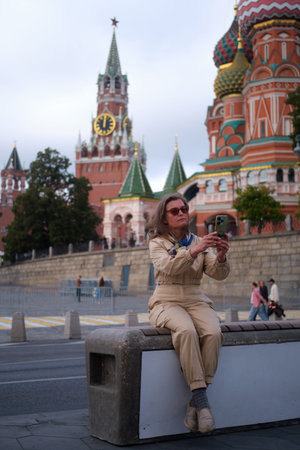Woman tourist takes a photo of an old city of famous landmark in Moscow, Russia. Adult female is...