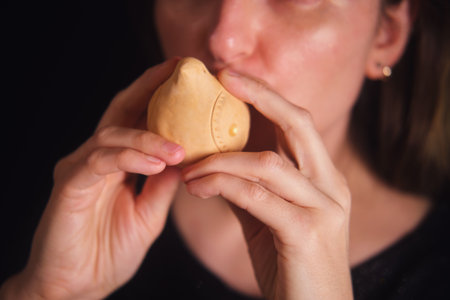 Woman playing traditional clay ocarina wind instrument close up. Folk music and cultural heritage for music education concept.の写真素材