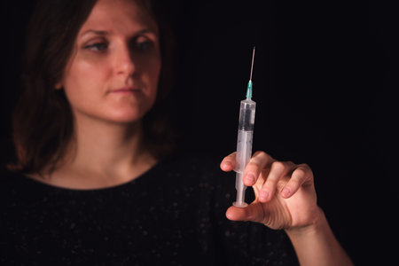 Woman holding a syringe with medicine. Medical injection tool for vaccination or drug administration. Healthcare and treatment concept.の写真素材