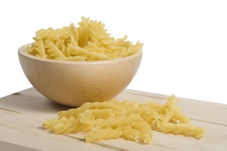 Spiral pasta in wooden dish and on wooden board, isolated on whiteの写真素材
