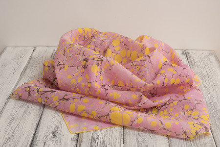Women's shawl made of cotton and silk on a white wooden background. Concept International Women's Dayの写真素材