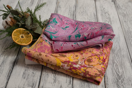 Women's shawl made of cotton and silk, on a light wooden background. Concept International Women's...