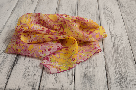 Women's shawl made of cotton and silk, on a light wooden background. Concept International Women's Dayの写真素材