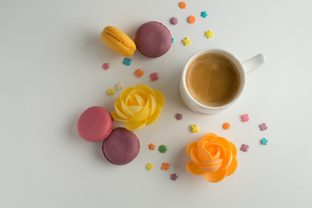 Biscuits macaron or macaroon on white background, colorful almond cookies with a cup of coffee, top view.の写真素材