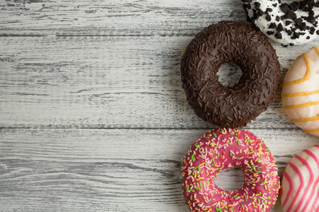 A donut with icing on white wooden background.の写真素材