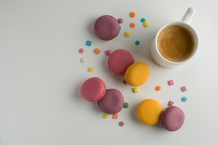 Biscuits macaron or macaroon on white background, colorful almond cookies with a cup of coffee, top view.の写真素材