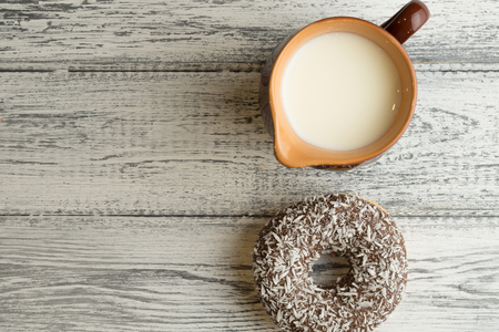 Donut with icing on white wooden background with milk jugの写真素材