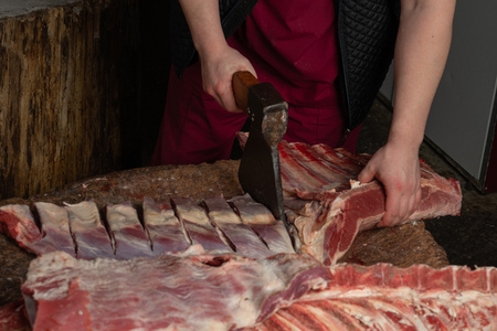 a butcher chopping meat with an axeの写真素材