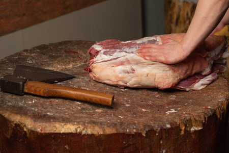 The butcher runs the butcher's knife to cut the lamb.の写真素材