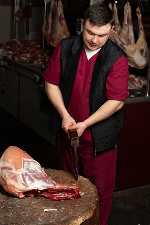 The chopping the meat, professional work of the butcherの写真素材