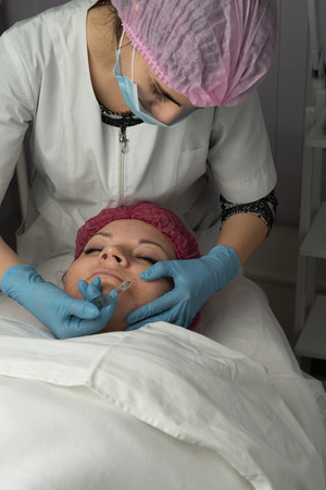 The beautician makes a shot for the faceliftの写真素材