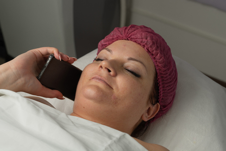 a patient is calling family after surgeryの写真素材