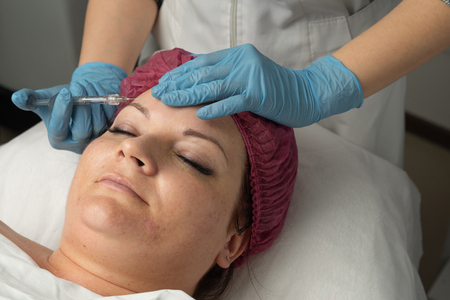 a beautician is making an injection the womanの写真素材