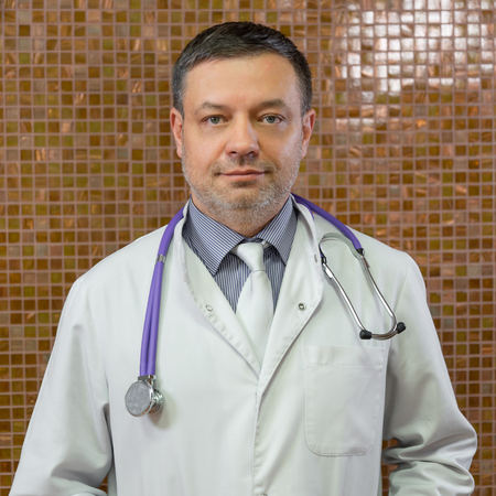 Close up a doctor with stethoscope around his neck looking at the cameraの写真素材