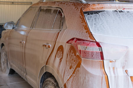 Car washing at car wash station with brush and foam.の写真素材