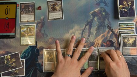 SOCHI, RUSSIA-MAY 17, 2019: Man lays out a set for the game in The War of the Spark Magic The Gathering. Top Viewのeditorial素材