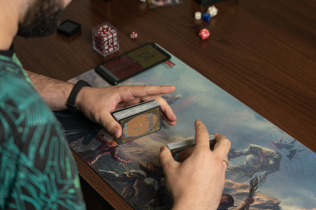 SOCHI, RUSSIA-MAY 17, 2019: Young hipster holding a deck of cards Magic The Gathering, New expansion game The War of the Sparkのeditorial素材