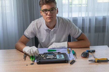 Man repairing laptop computer in service center. Repairing and fixing service. Electronics repair service concept.の写真素材