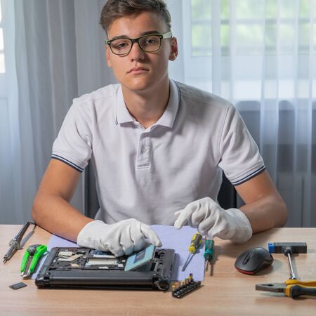 Young man is repairing laptop motherboard in the service centerの写真素材
