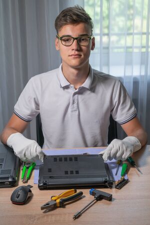 Service worker and IT specialist at the workplace. Service center for laptop repairの写真素材