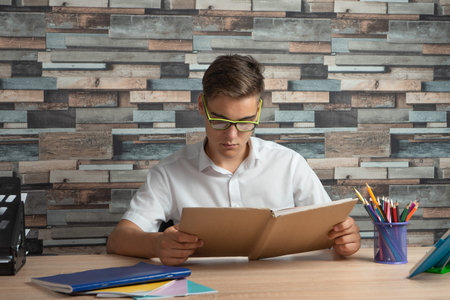 Teenager reading a book and doing homework. Concept of education