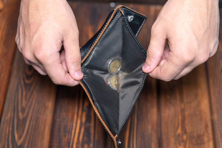Close-up of a dark leather wallet. Purse with coins inside, focus on your hands
