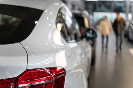 Rear view of the part of a white luxury vehicle in a motor show. The concept of selling cars by dealers in a car dealershipの写真素材