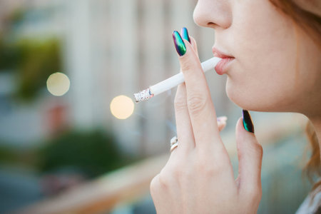 girl with a cigarette. young beautiful woman smokes a cigarette in the streetの写真素材