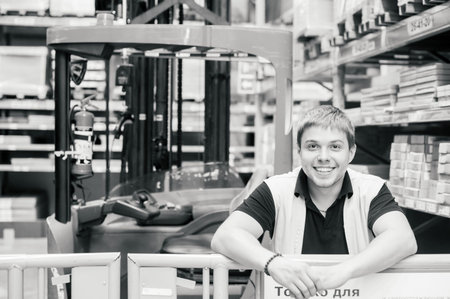 young man in working clothes, driver Reachtruck busy working on the logistics warehouse store