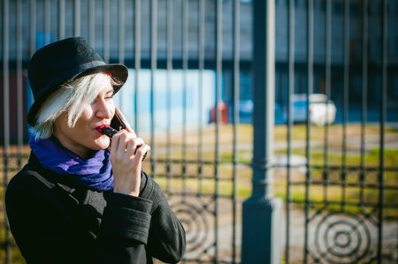 portrait of young beautiful woman with white hair, in a black coat, a skirt and a black hat, smoking...