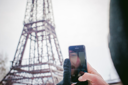man near the Eiffel Tower in Siberia. walking outdoors in winter. photographs on the phone's cameraの写真素材