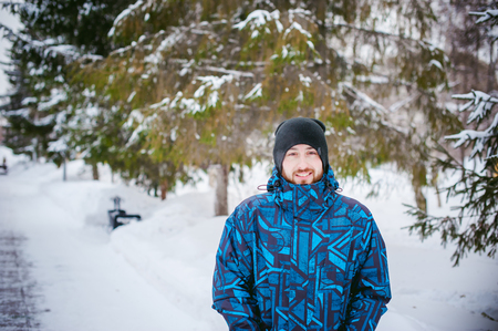 men walk in a winter park. guy with good humor and smile, warm clothing walking outdoorsの写真素材