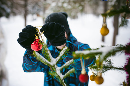 men walk in a winter park. guy with good humor and smile, warm clothing walking outdoors, dress up a Christmas tree decorations on the streetの写真素材