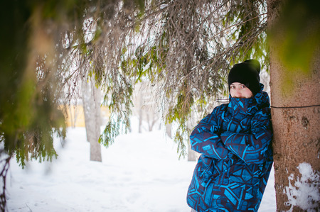 men walk in a winter park. guy with good humor and smile, warm clothing walking outdoorsの写真素材