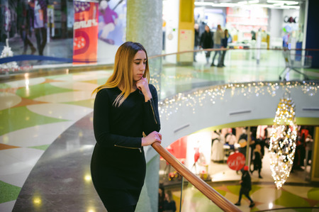 young woman in a black dress shopping mallの写真素材