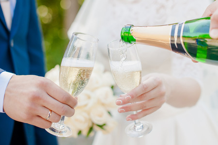 bride and groom in the park with champagne;の写真素材