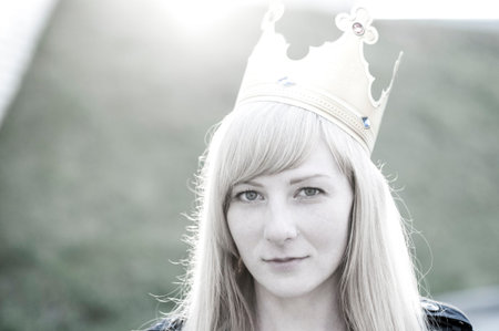 blond woman with a pretty face in the paper crown on the street