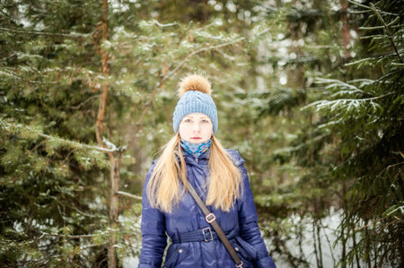 portrait of a girl in warm clothes in a forestの写真素材